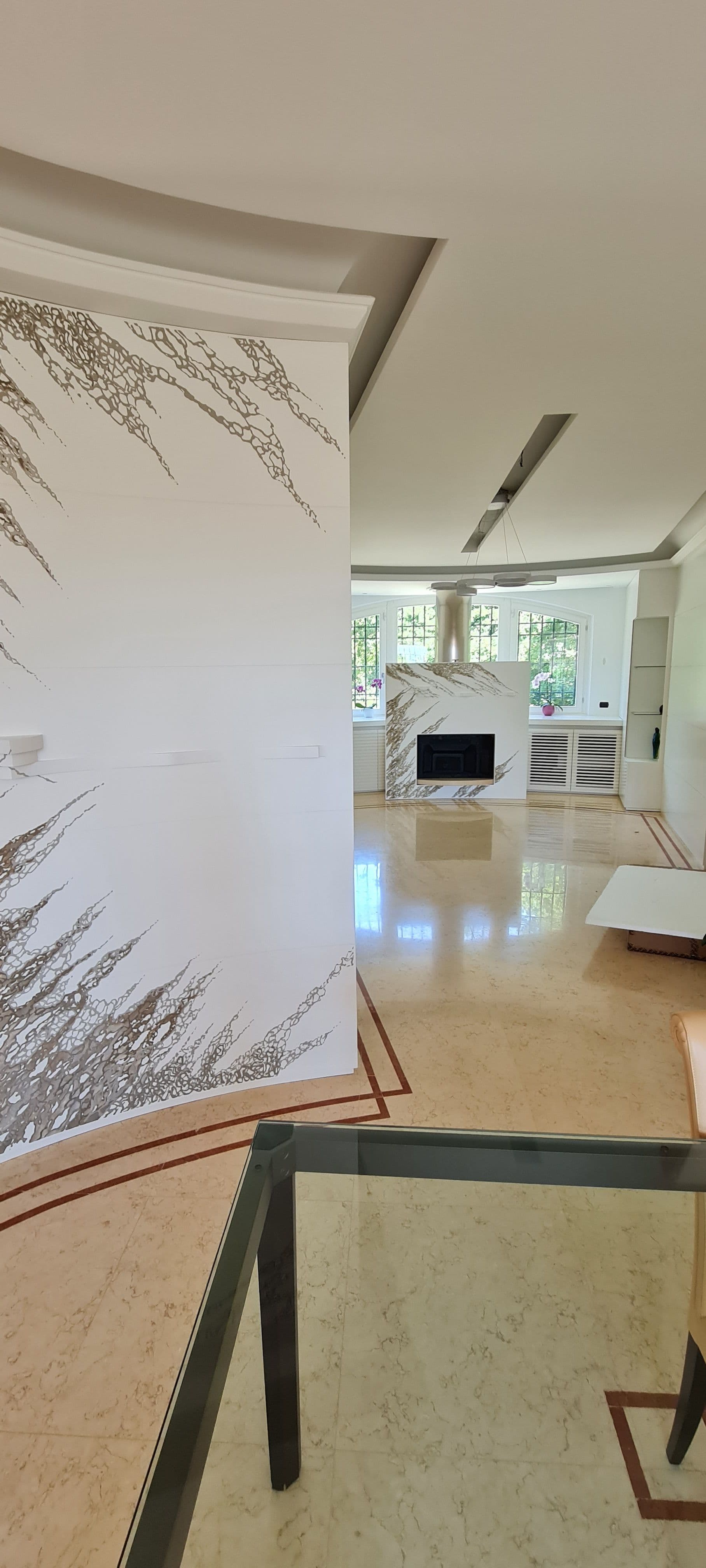Scorcio dell'ambiente giorno con il pannello decorativo in primo piano e il camino sullo sfondo.