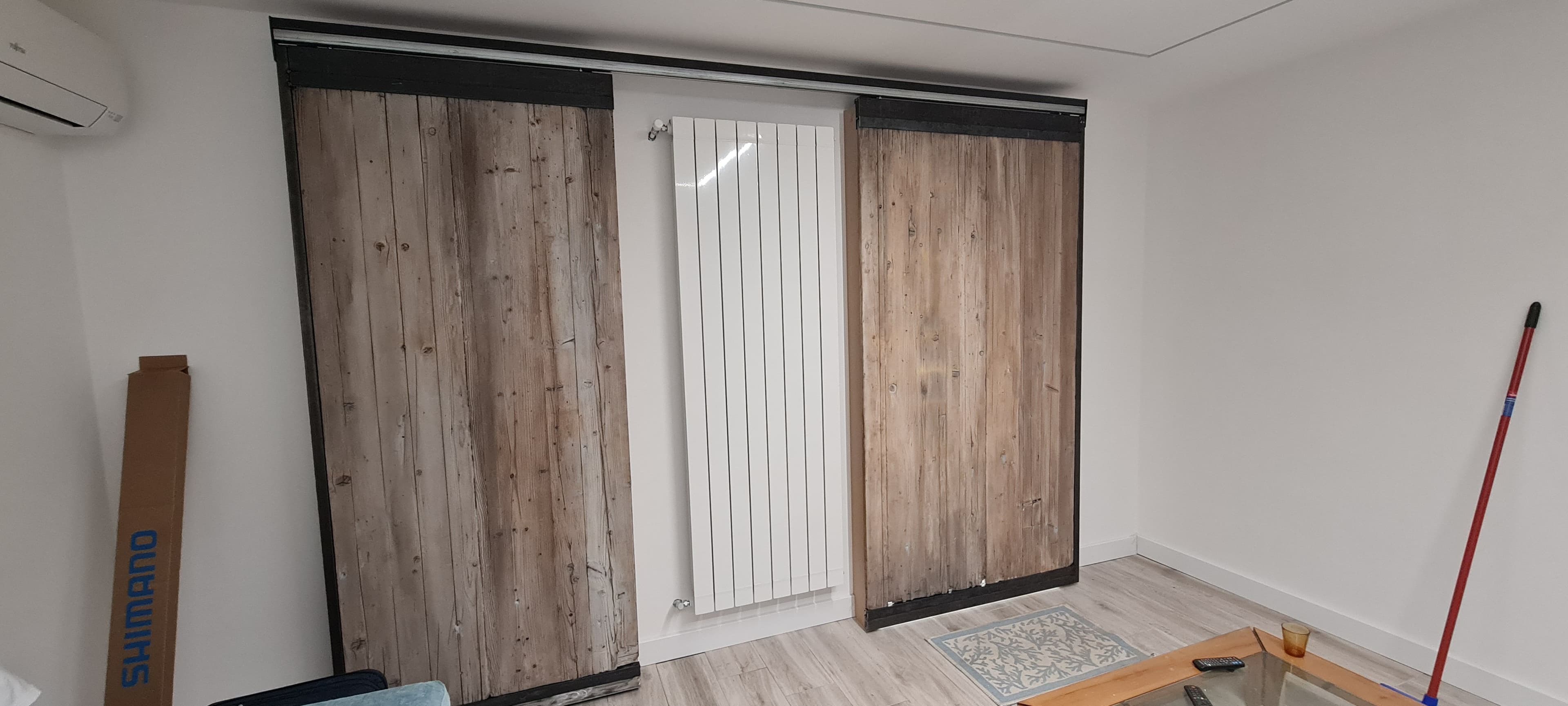 Porte scorrevoli installate nella residenza privata ai lati di un termosifone verticale