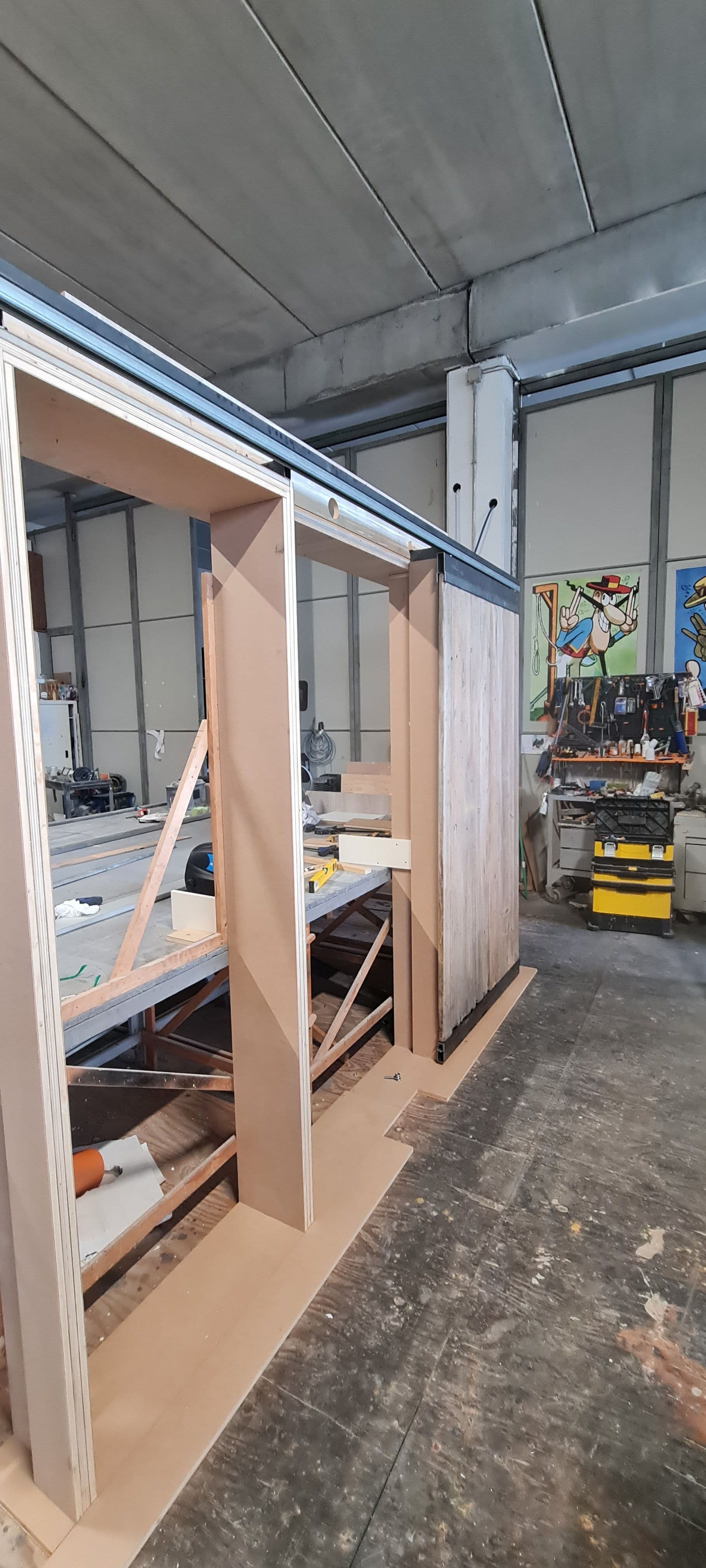 Vista angolare del telaio in legno e del pannello scorrevole in fase di collaudo